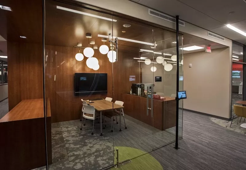 TILL Collaborate Room with small conference table and TV, surrounded by glass walls