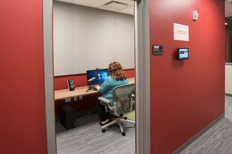 TILL recording studio with a woman working on computer inside