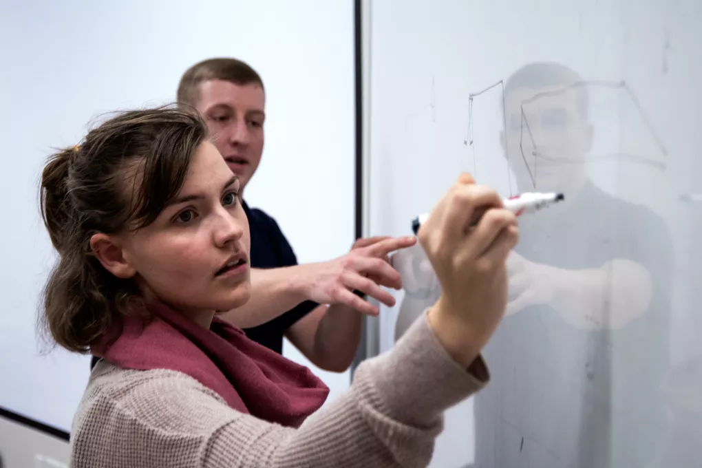 Student writes on a white board