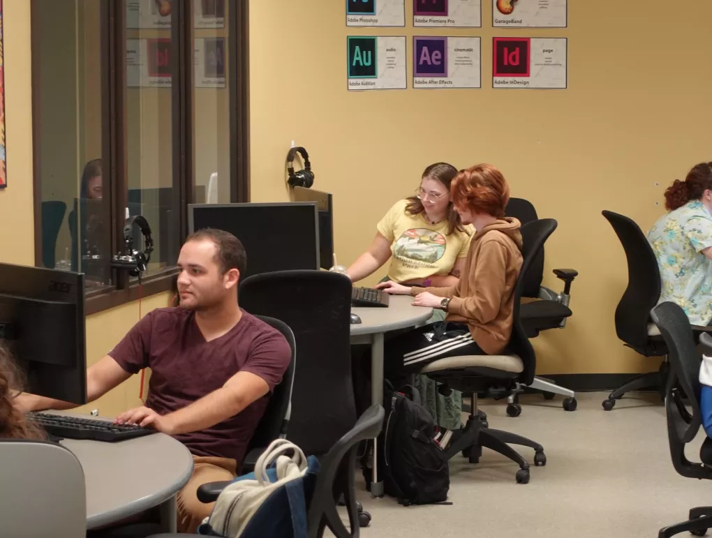 Students partnering in front of laptop.