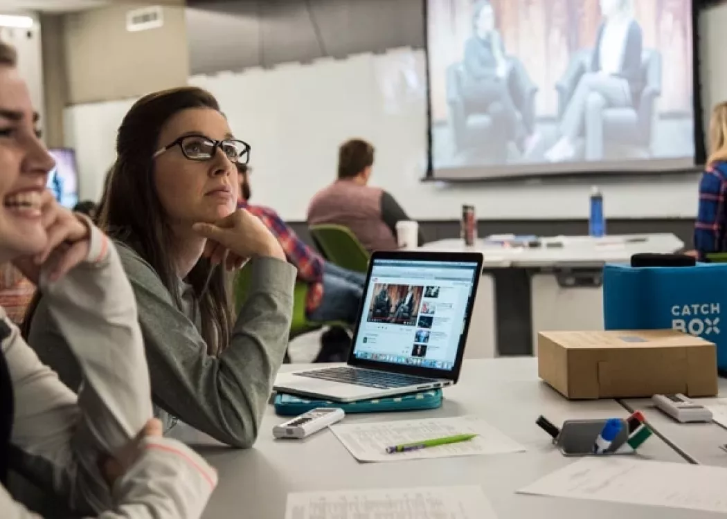 Students at table watching a video on screens in the TILL classroom