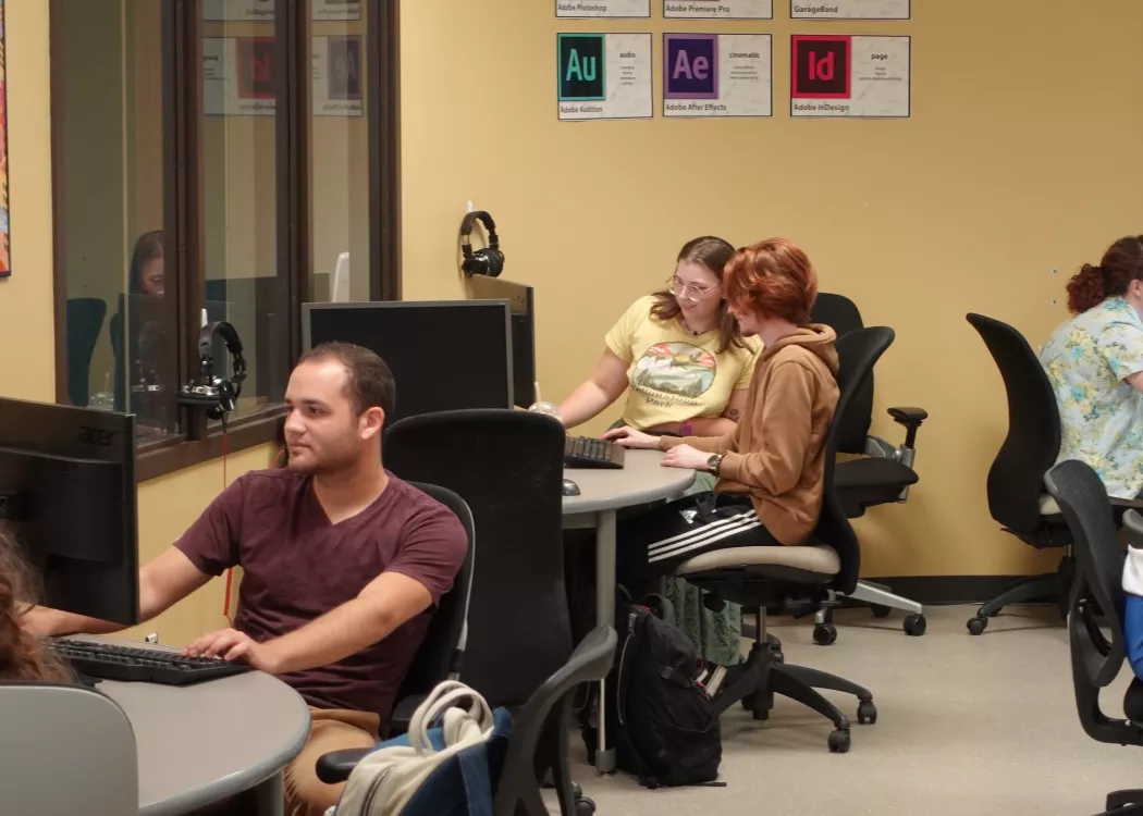 Students partnering in front of laptop.