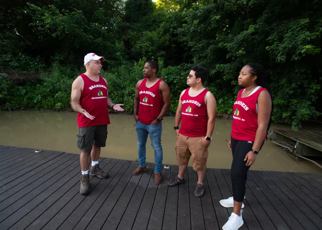 Dr. Tony Arnold in discussion with three students, standing on a dock.