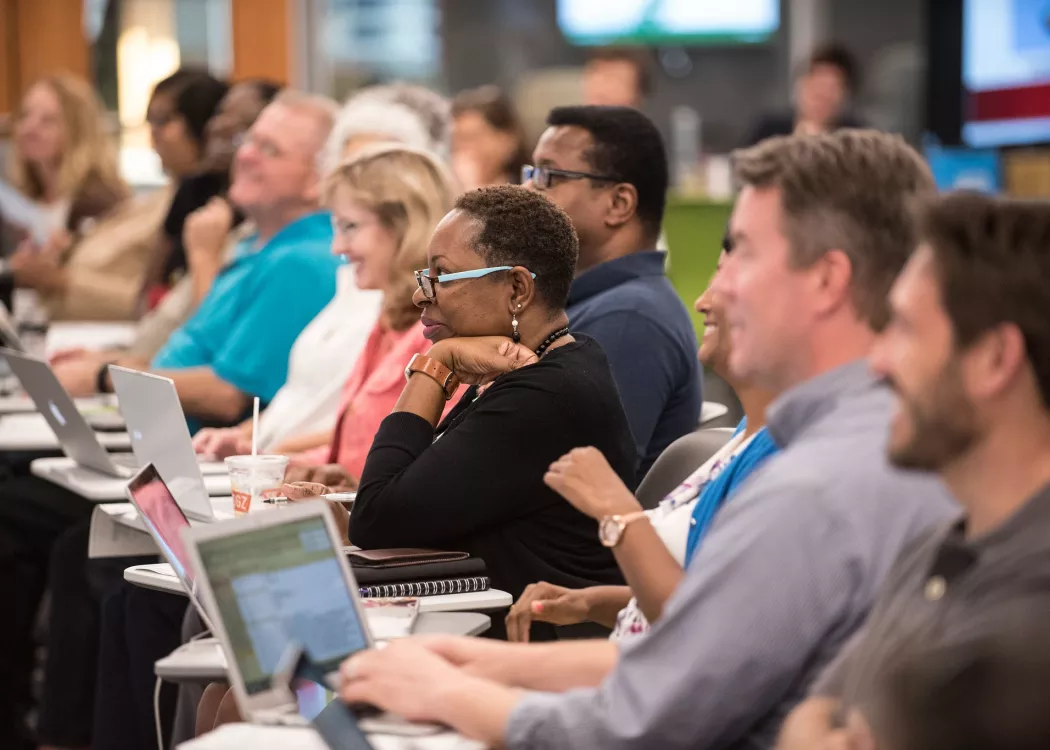 Group of instructors smiling and looking at session leader.