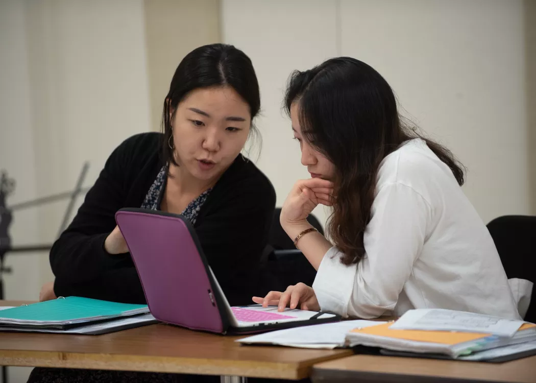Music students in a Cardinal Singers class working at a table with a laptop
