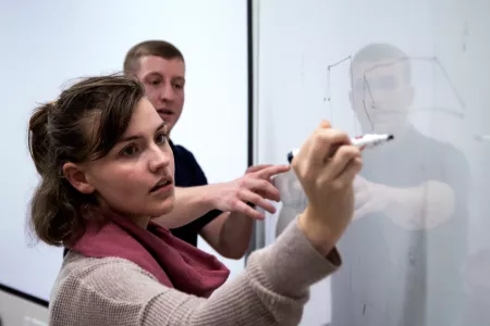 Student writes on a white board
