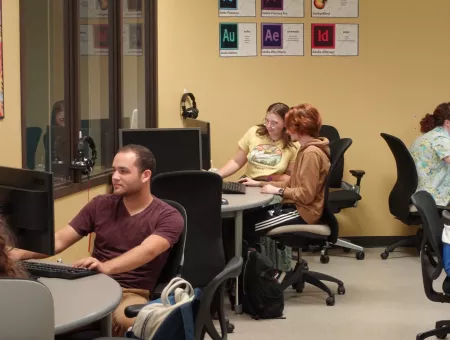 Students partnering in front of laptop.